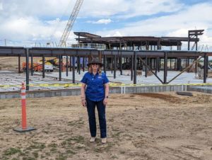 Jody stands in front of a construction project.